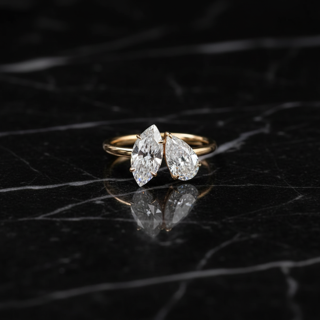 Anello con diamanti marquise in oro giallo su marmo nero