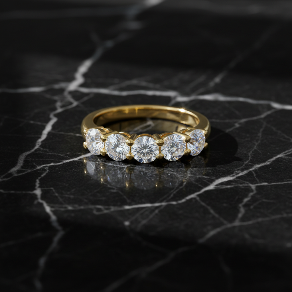 Five-stone diamond ring in yellow gold on black marble