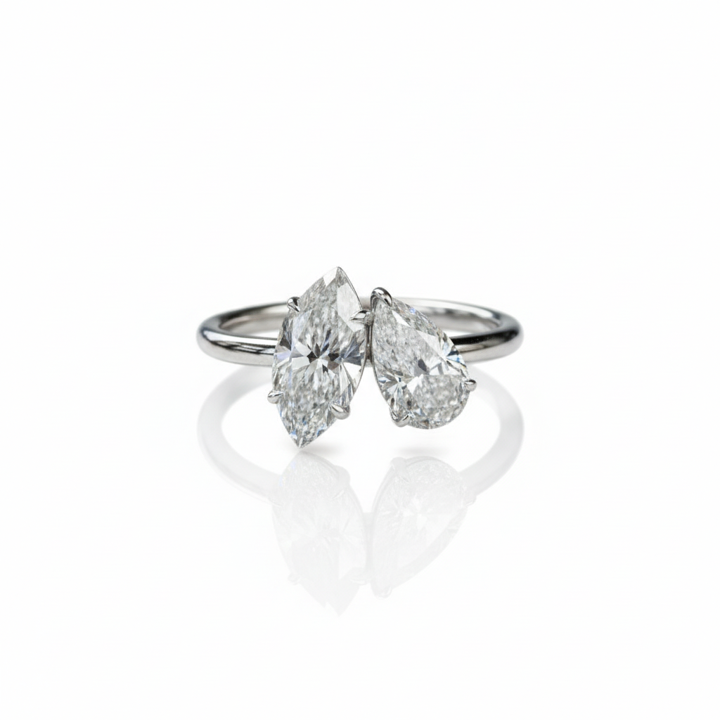 Two stone ring with marquise and pear diamonds on white background